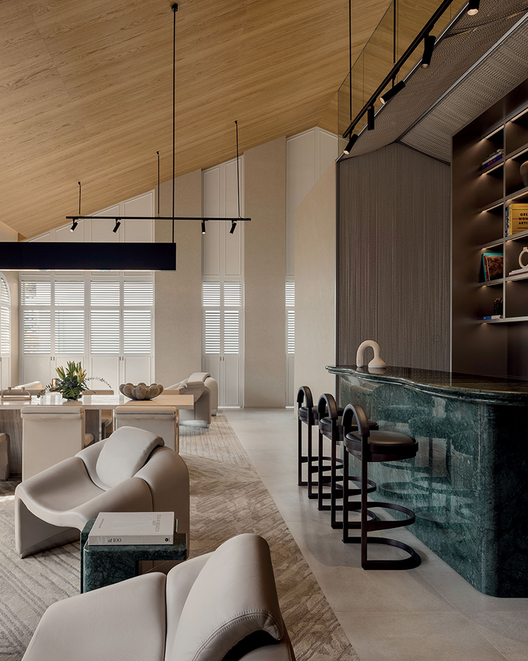 Modern lounge with beige armchairs and a green marble bar. Wooden ceiling, soft natural light, neutral tones, and a calm, sophisticated ambiance.
