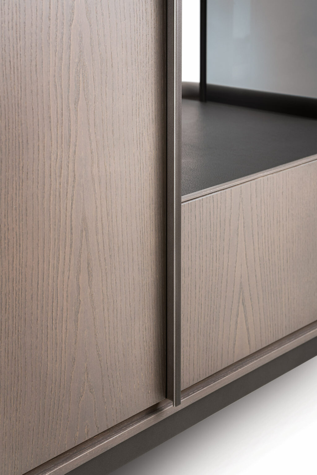 Close-up of a modern brown cabinet with a light brown wooden finish, featuring a prominent grain pattern. The metal edge adds a modern touch, creating a sleek and minimalistic design.
