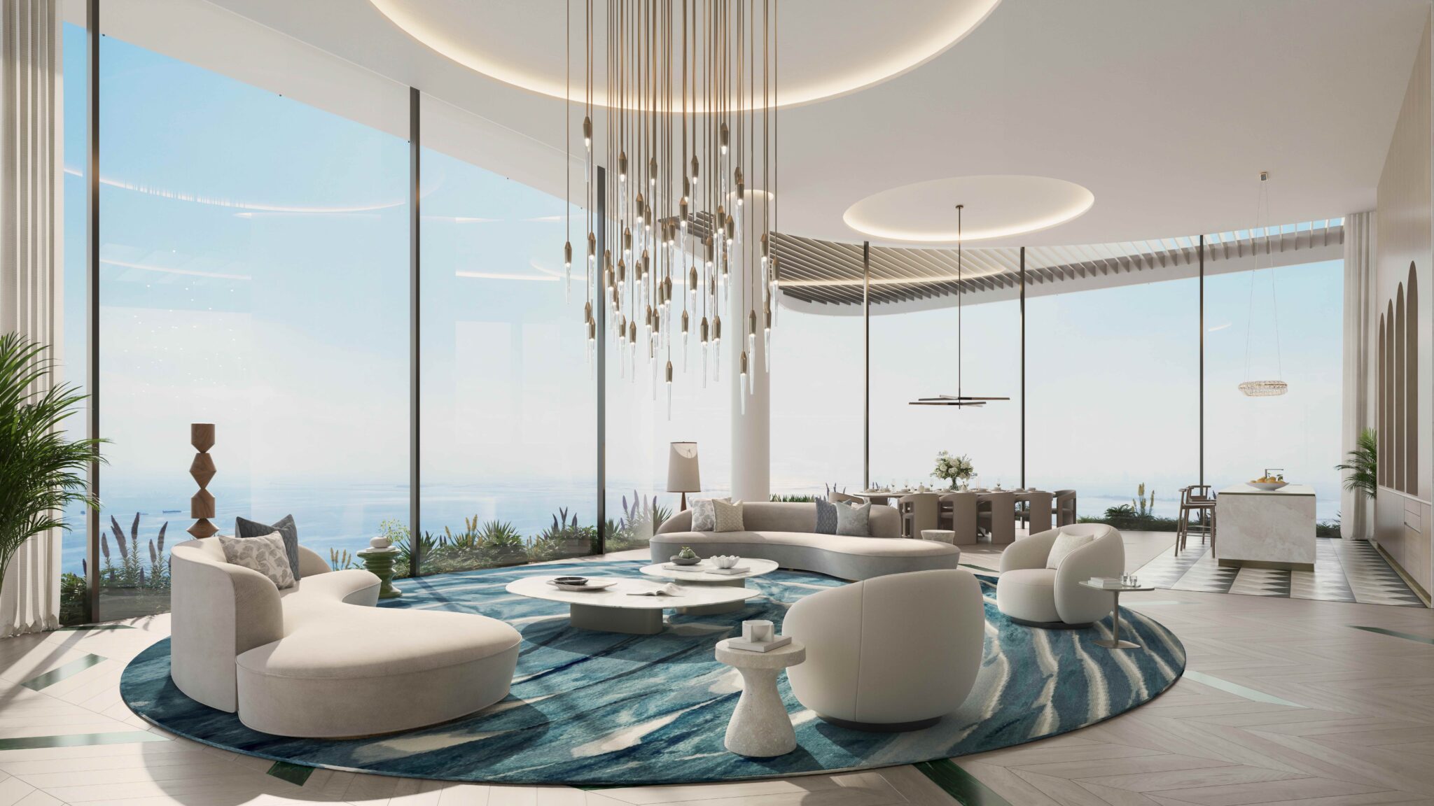 Luxurious modern living room with ocean view, featuring curved white sofas, a large abstract chandelier, and a blue-patterned rug, exuding elegance.