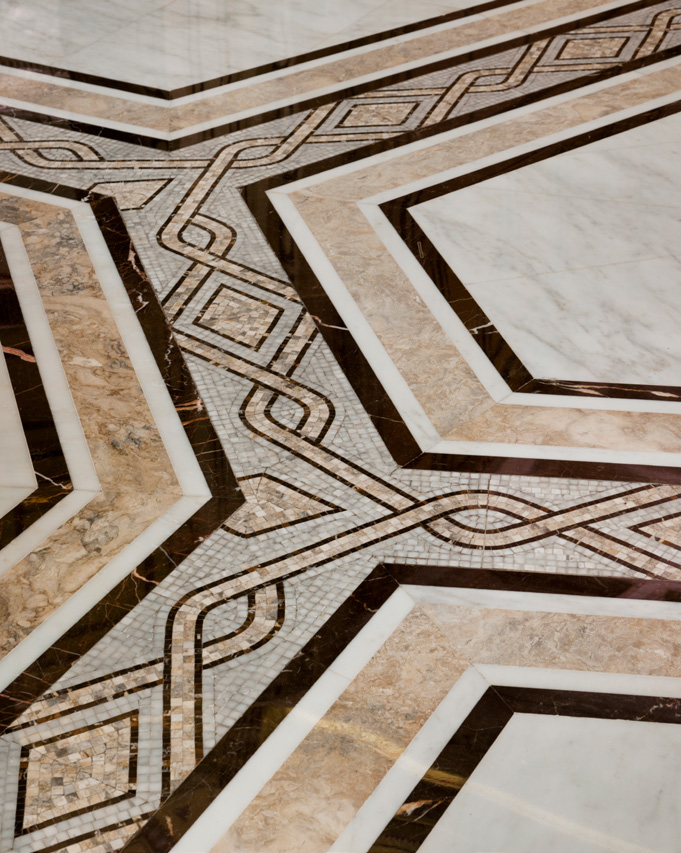 Intricate marble floor with geometric patterns and interlocking designs in shades of brown and cream, creating a sophisticated and elegant ambiance.