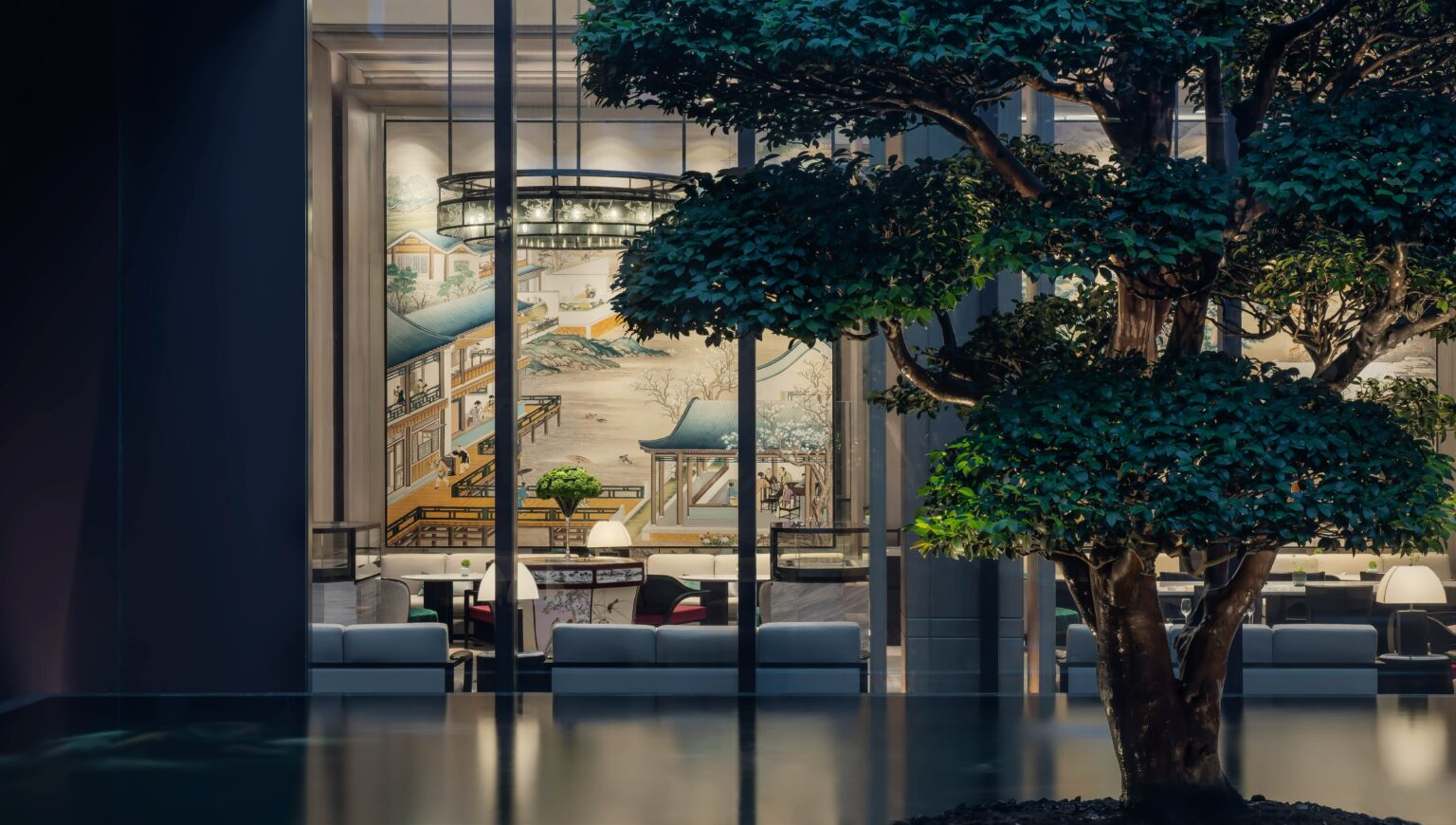 Modern hotel lounge with minimalist decor viewed through large windows. A mural of traditional Asian architecture is visible inside, with lush green trees outside.