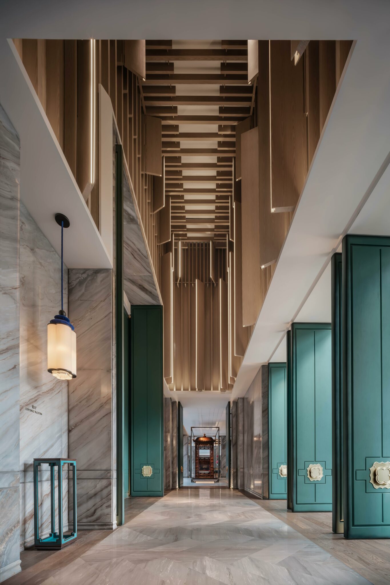 Modern, luxurious hotel hallway with a geometric wooden ceiling, marble walls, and teal doors. A warm pendant lamp adds elegance and depth to the space.