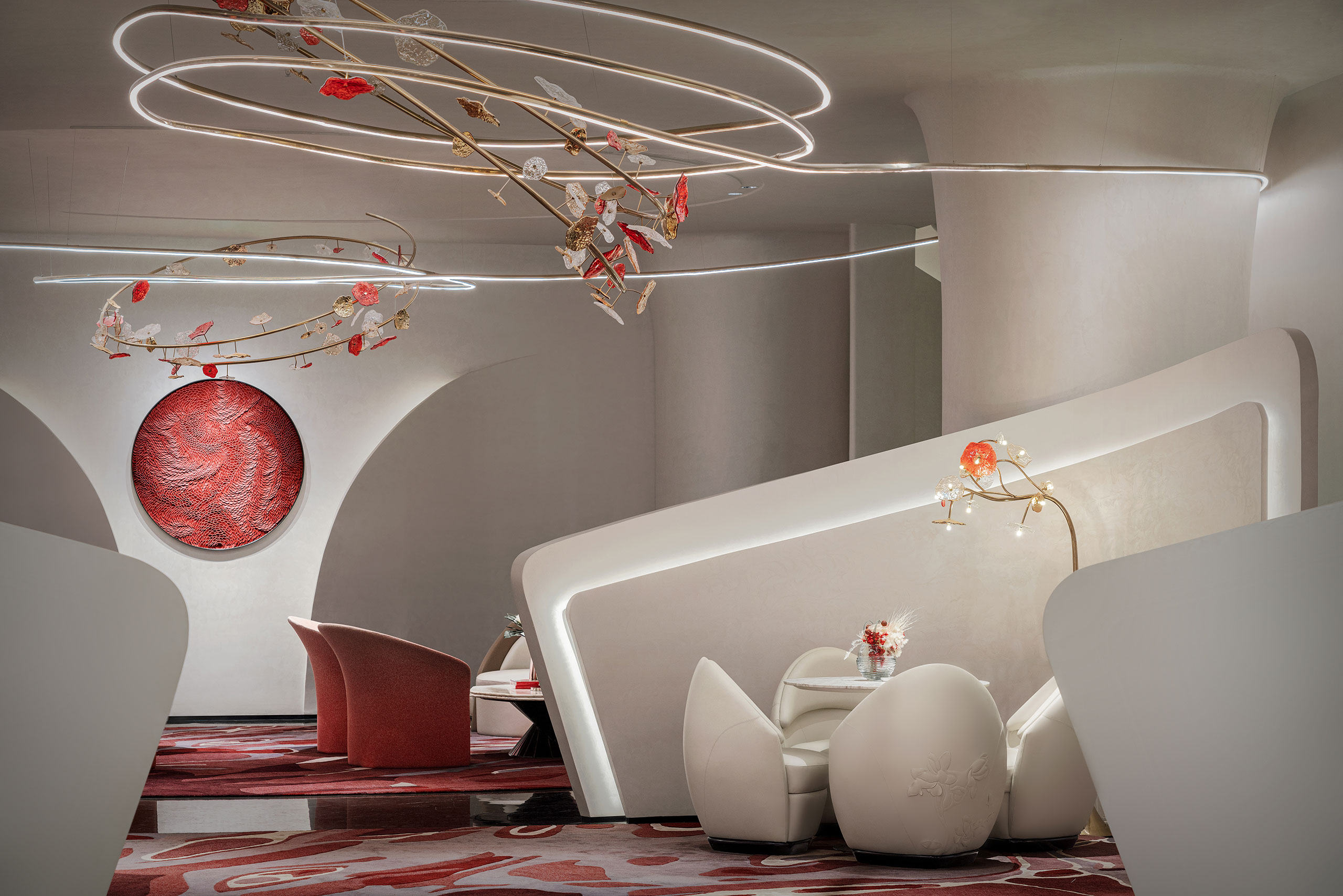 Futuristic interior with sleek white furniture, abstract red art, and circular lights with floral decorations. The ambiance is modern and elegant.