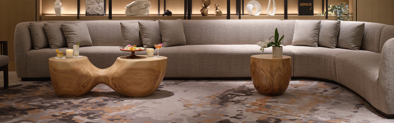 Curved gray sectional sofa with sculptural wood coffee tables in the lobby of the Intercontinental Bellevue at the Avenue, Washington