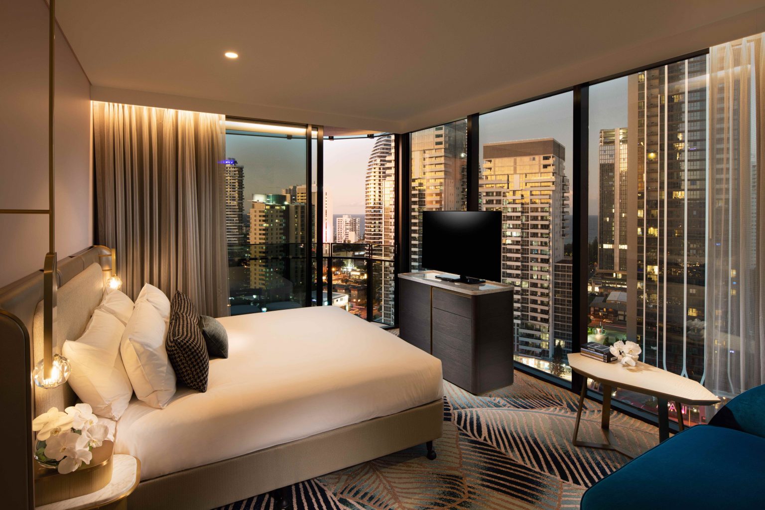 Elegant hotel room with a king-size bed, soft lighting, and contemporary design. Features a modern partitioned bathroom and cozy seating area.