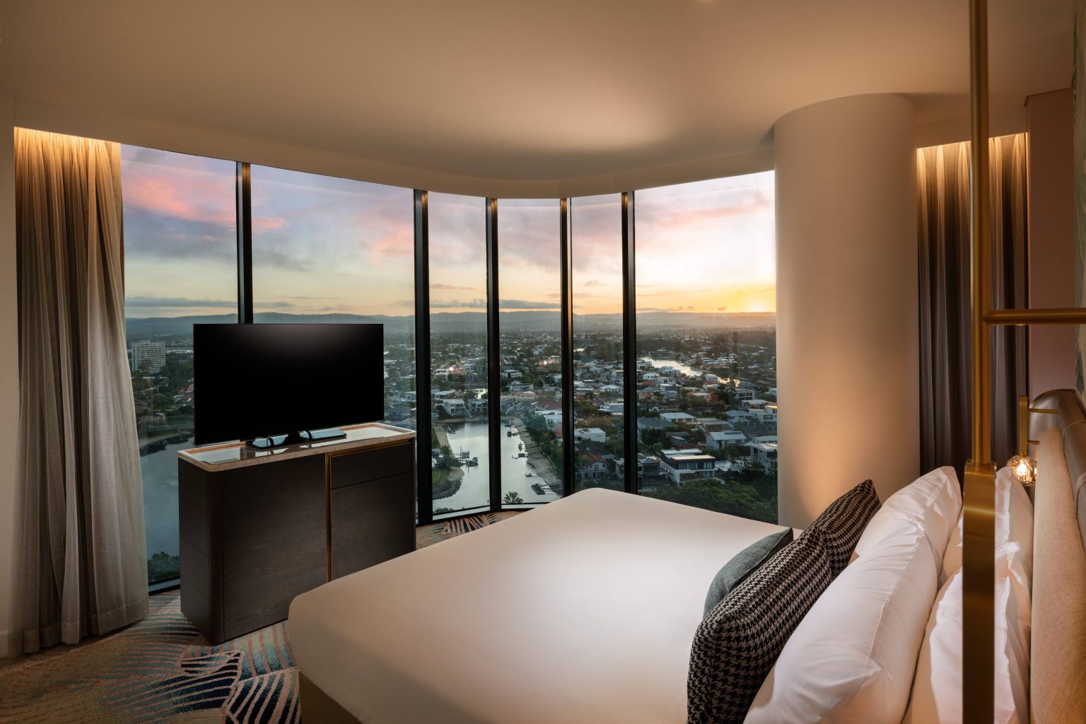 Elegant hotel room with a king-size bed, soft lighting, and contemporary design. Features a modern partitioned bathroom and cozy seating area.