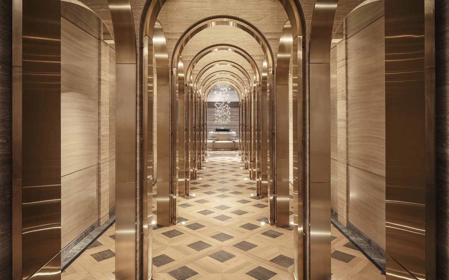 Luxurious resort spa interior with arched golden doorways and marble walls. A person in a white robe walks through the opulent, serene hallway.