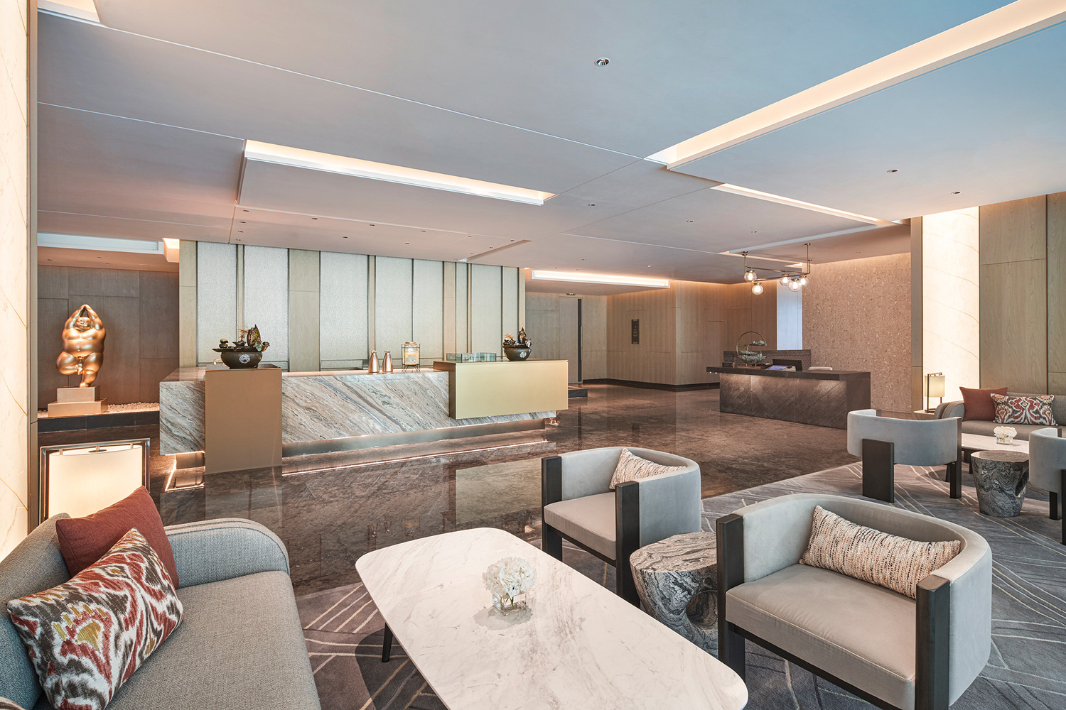 Modern hotel lobby with a sleek marble reception desk, vibrant teal and red shelving, elegant lighting, and a lush indoor tree. The space conveys luxury.