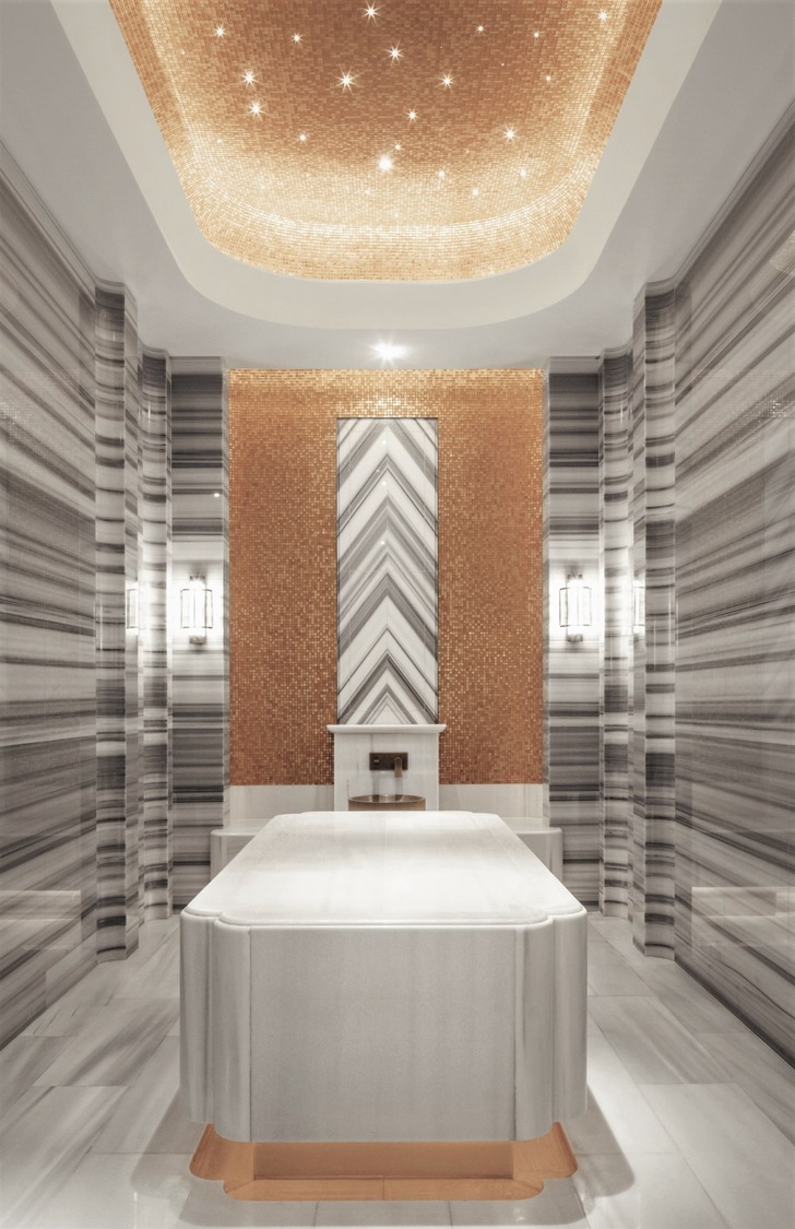 Luxurious resort spa interior with arched golden doorways and marble walls. A person in a white robe walks through the opulent, serene hallway.