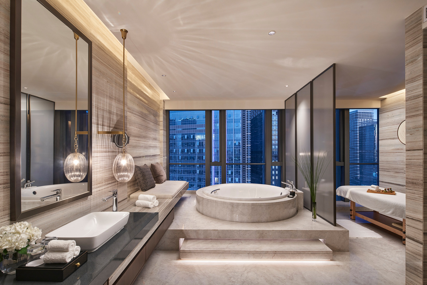 Modern bathroom with a freestanding oval tub, beige tile walls, a large window with sheer curtains, minimalist decor, and a serene, luxurious ambiance.