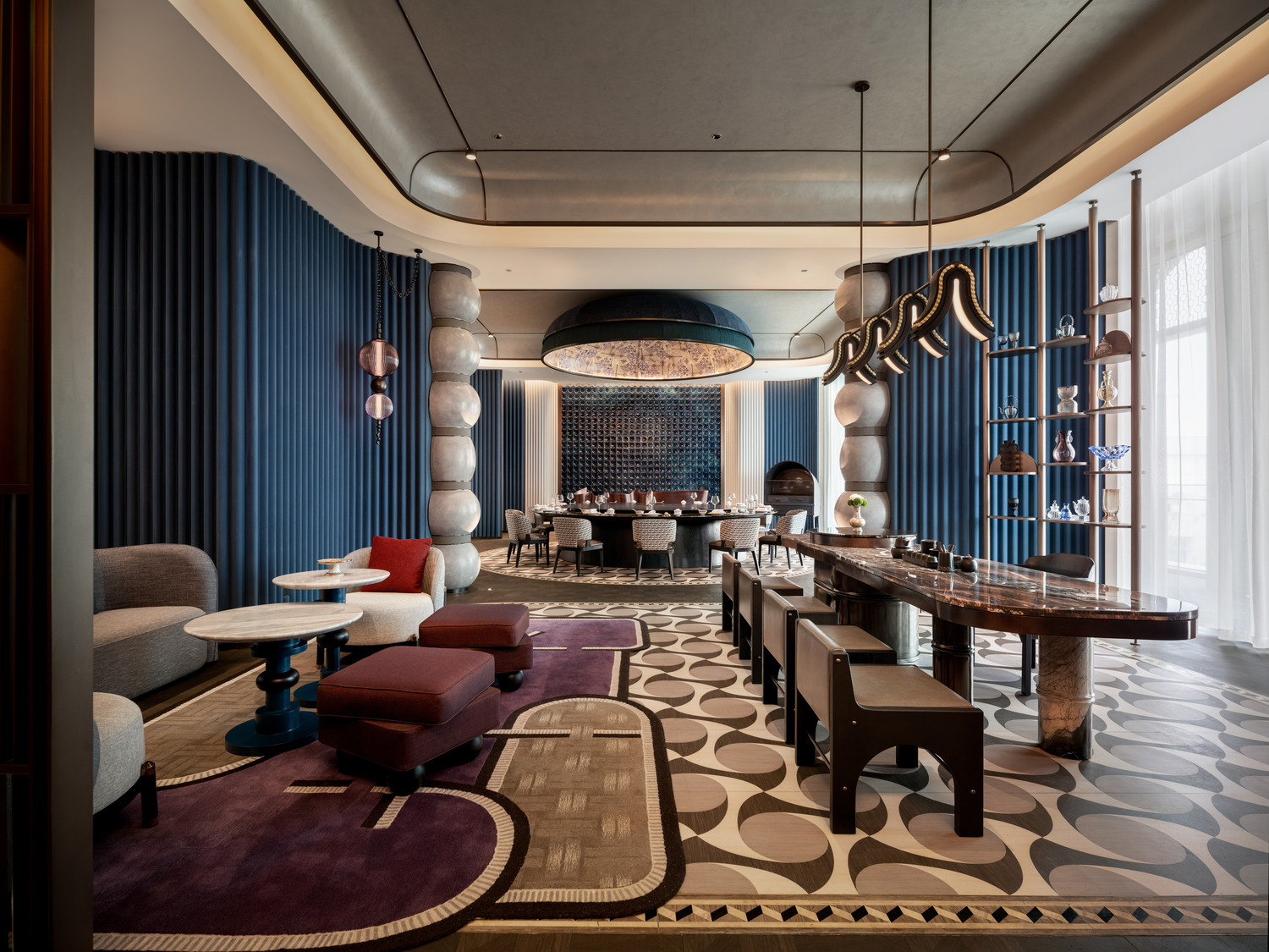A grand hotel lobby featuring a dramatic chandelier, elegant seating areas, and a sweeping staircase, creating a luxurious and inviting atmosphere for guests to relax and socialize.