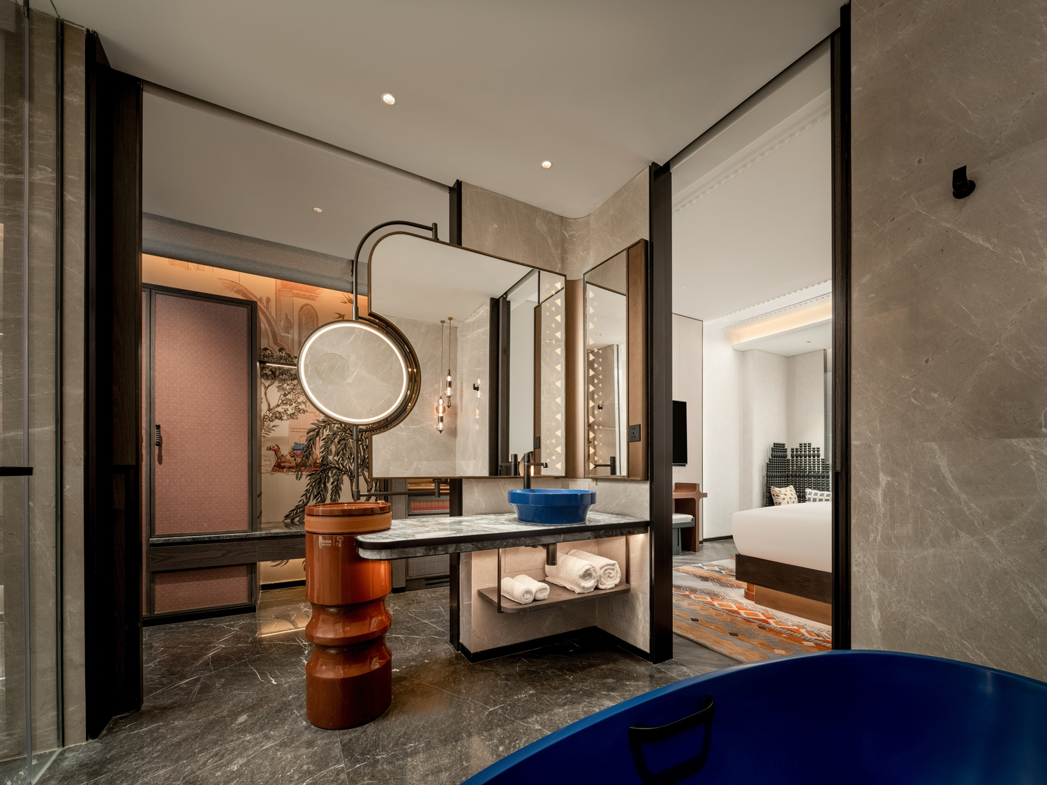 Luxurious hotel suite with modern decor, featuring a plush bed, abstract art, a large TV, and elegant seating. Warm lighting creates a cozy ambiance.