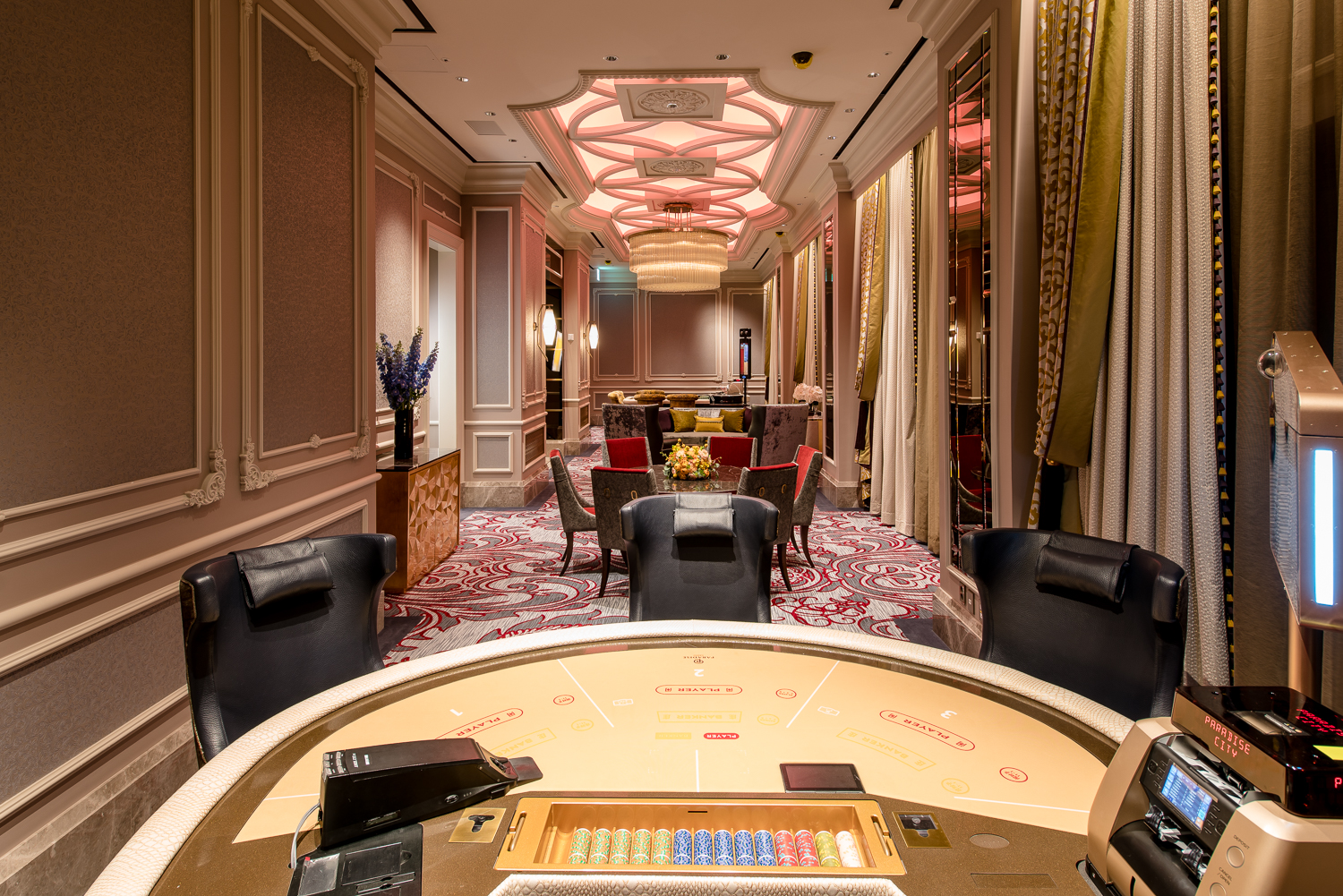 A vibrant casino interior featuring luxurious chandeliers, colorful slot machines, and stylish gaming tables, creating an energetic and glamorous atmosphere for guests seeking entertainment and excitement.