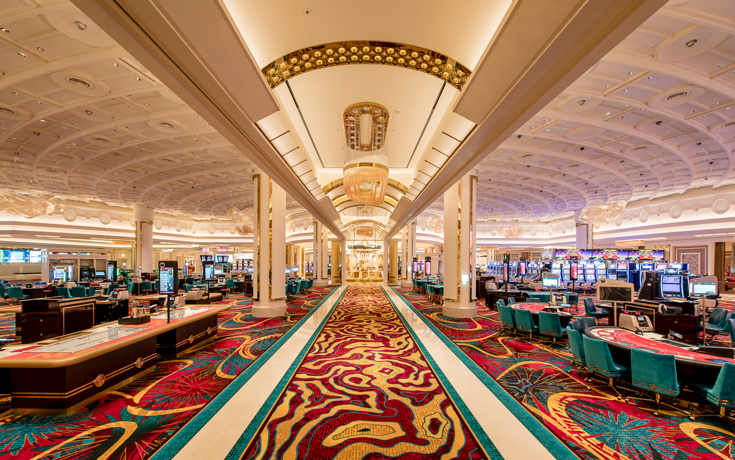 A vibrant casino interior featuring luxurious chandeliers, colorful slot machines, and stylish gaming tables, creating an energetic and glamorous atmosphere for guests seeking entertainment and excitement.