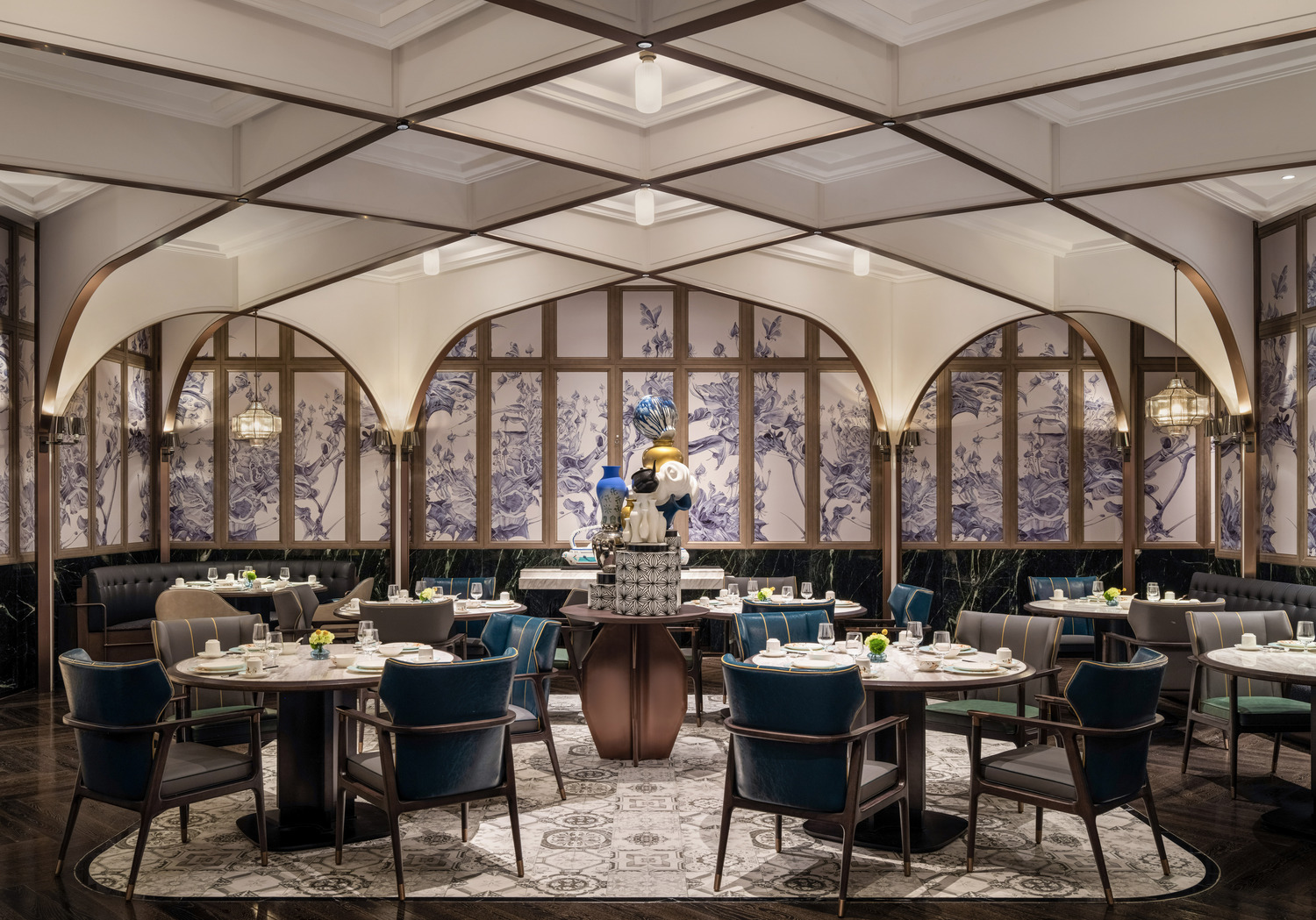 Luxurious hotel lobby with high ceiling and string lights. Features elegant sofas, coffee tables, and potted trees. Airy and sophisticated ambiance.