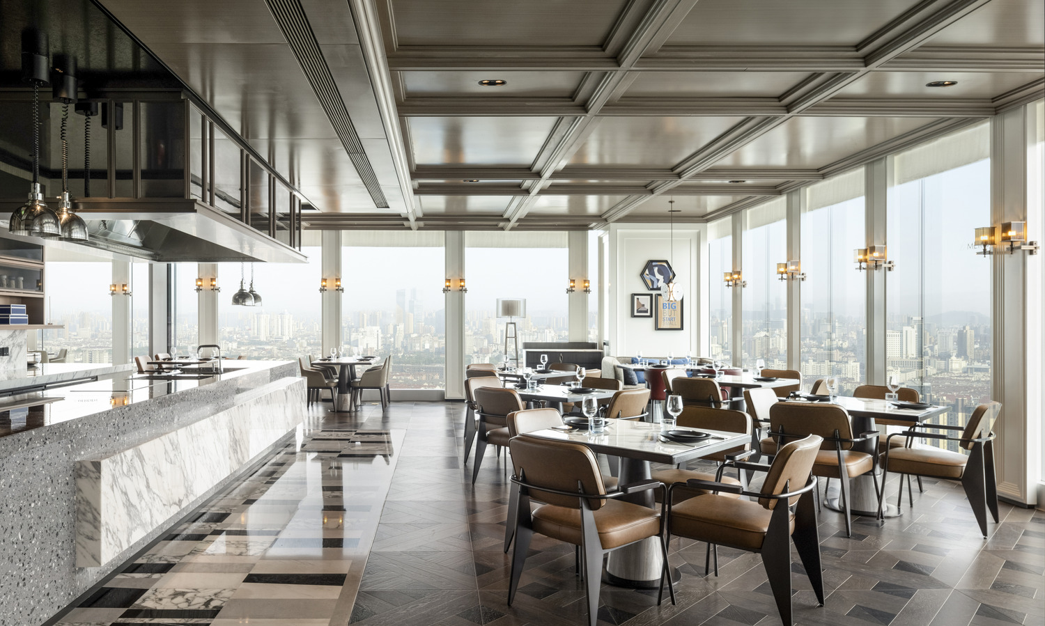 Elegant modern restaurant interior within a luxurious resort featuring geometric ceiling lights, wooden floors, and stylish beige chairs around round tables, creating a warm, inviting ambiance.
