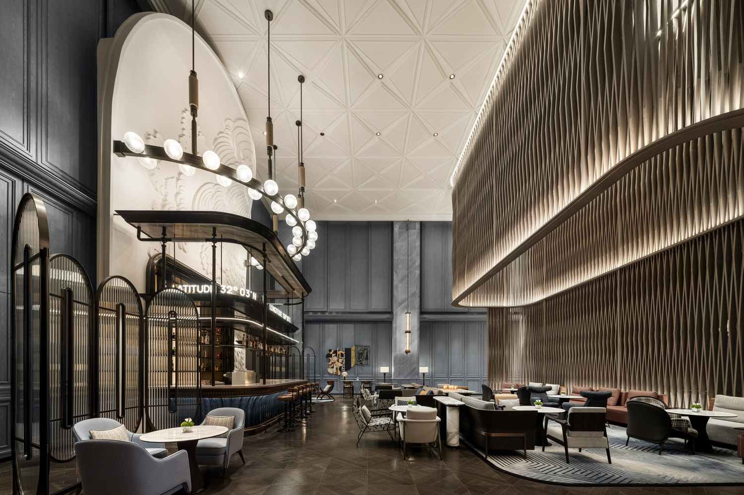 A grand hotel lobby featuring a dramatic chandelier, elegant seating areas, and a sweeping staircase, creating a luxurious and inviting atmosphere for guests to relax and socialize.