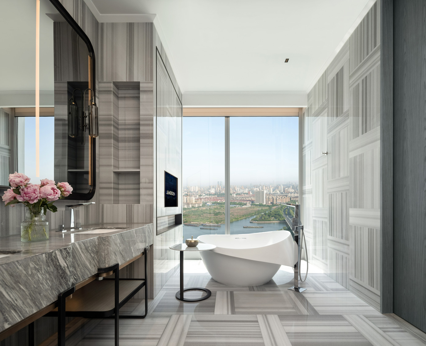 Modern bathroom with a freestanding oval tub, beige tile walls, a large window with sheer curtains, minimalist decor, and a serene, luxurious ambiance.