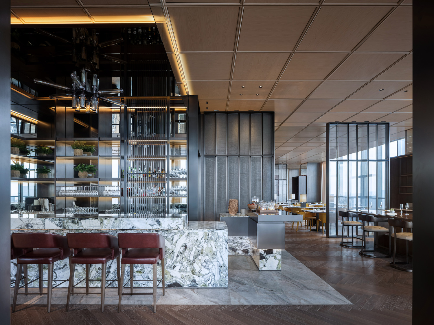 Modern hotel lobby with a sleek marble reception desk, vibrant teal and red shelving, elegant lighting, and a lush indoor tree. The space conveys luxury.