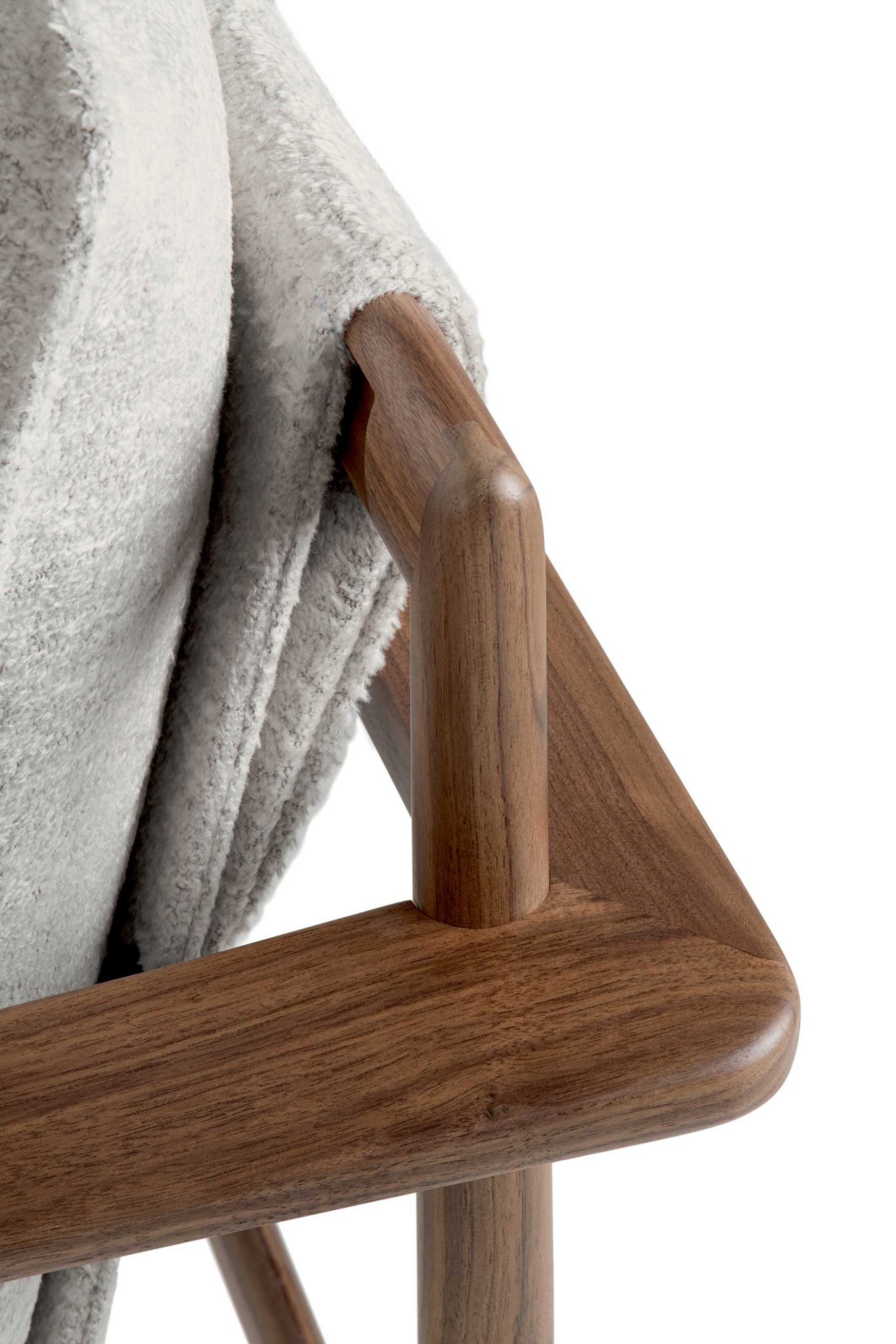 Close-up of Giorgetti Kumiki leg joint made of smooth, polished wood with a soft gray cushion. The image evokes a sense of modern elegance and minimalism.