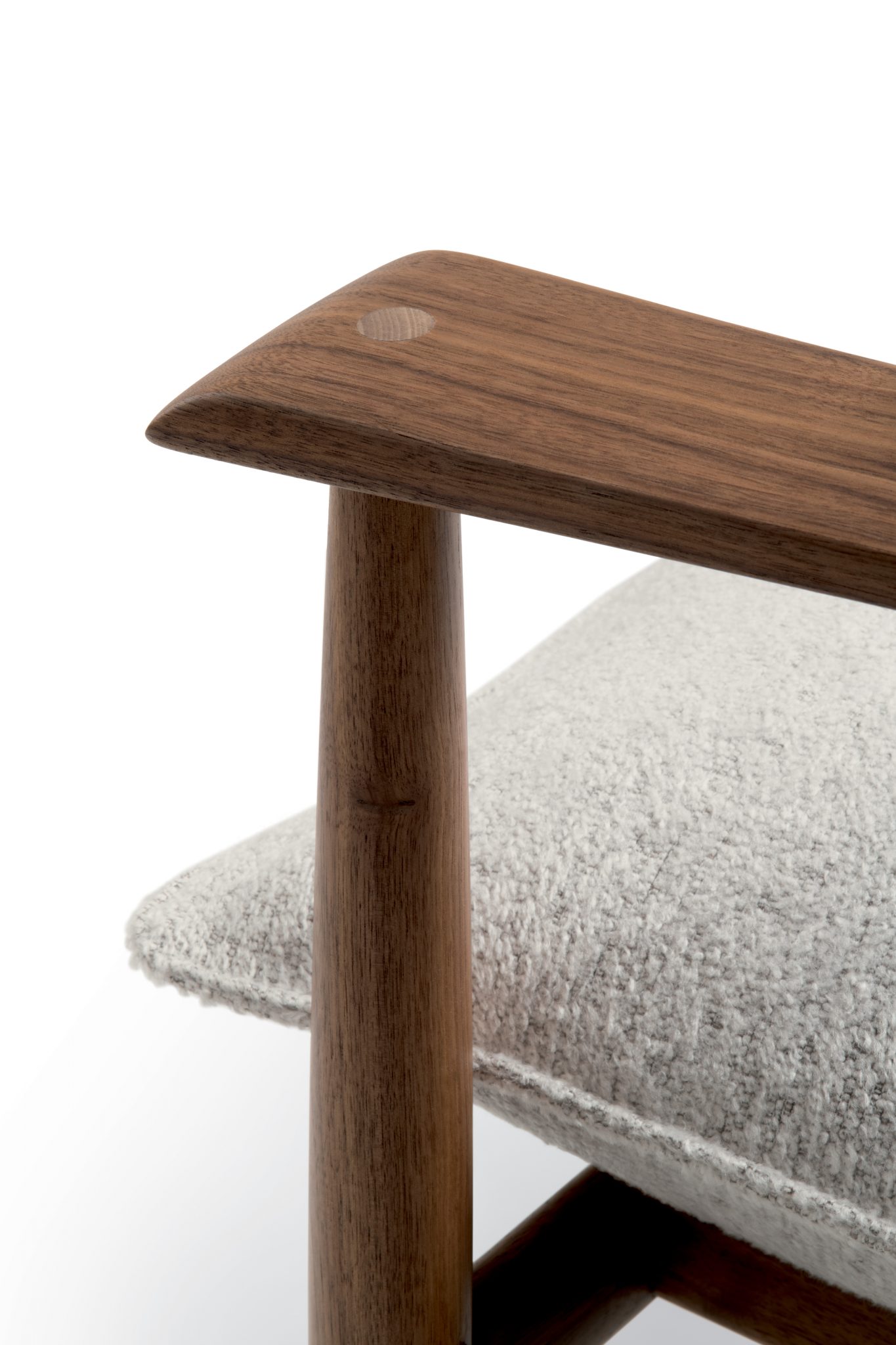 Close-up of Giorgetti Kumiki armrest made of smooth, polished wood with a soft gray cushion. The image evokes a sense of modern elegance and minimalism.
