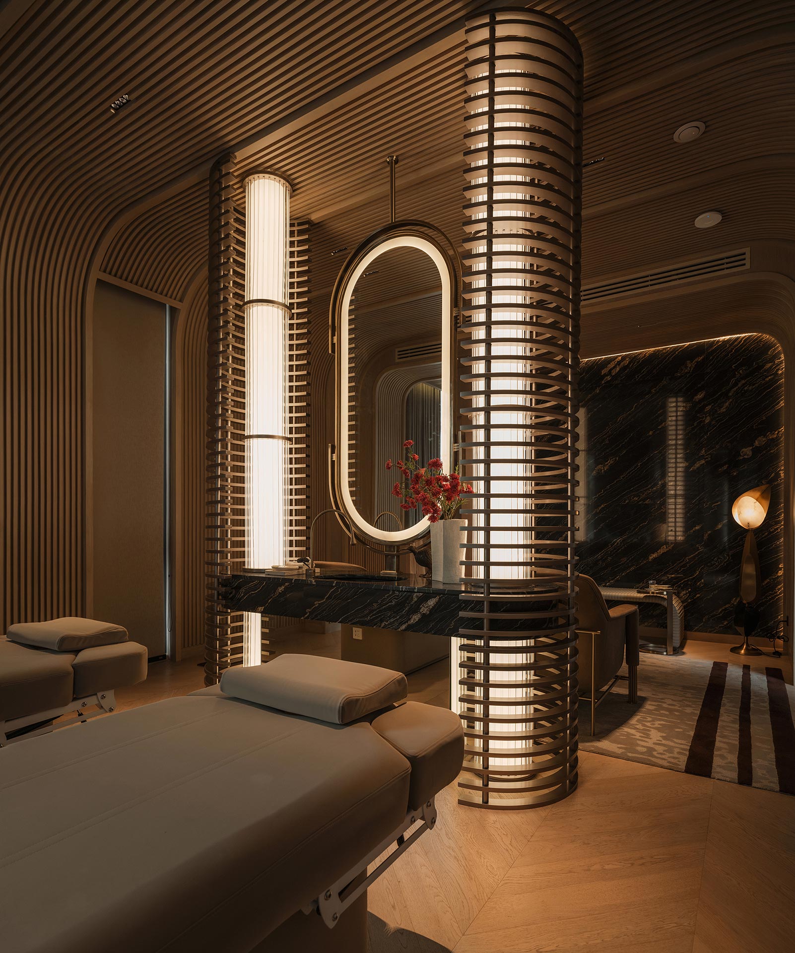 Luxurious spa room with a modern design, featuring two massage tables and a backlit mirror. Soft lighting creates a calm, relaxing ambiance.
