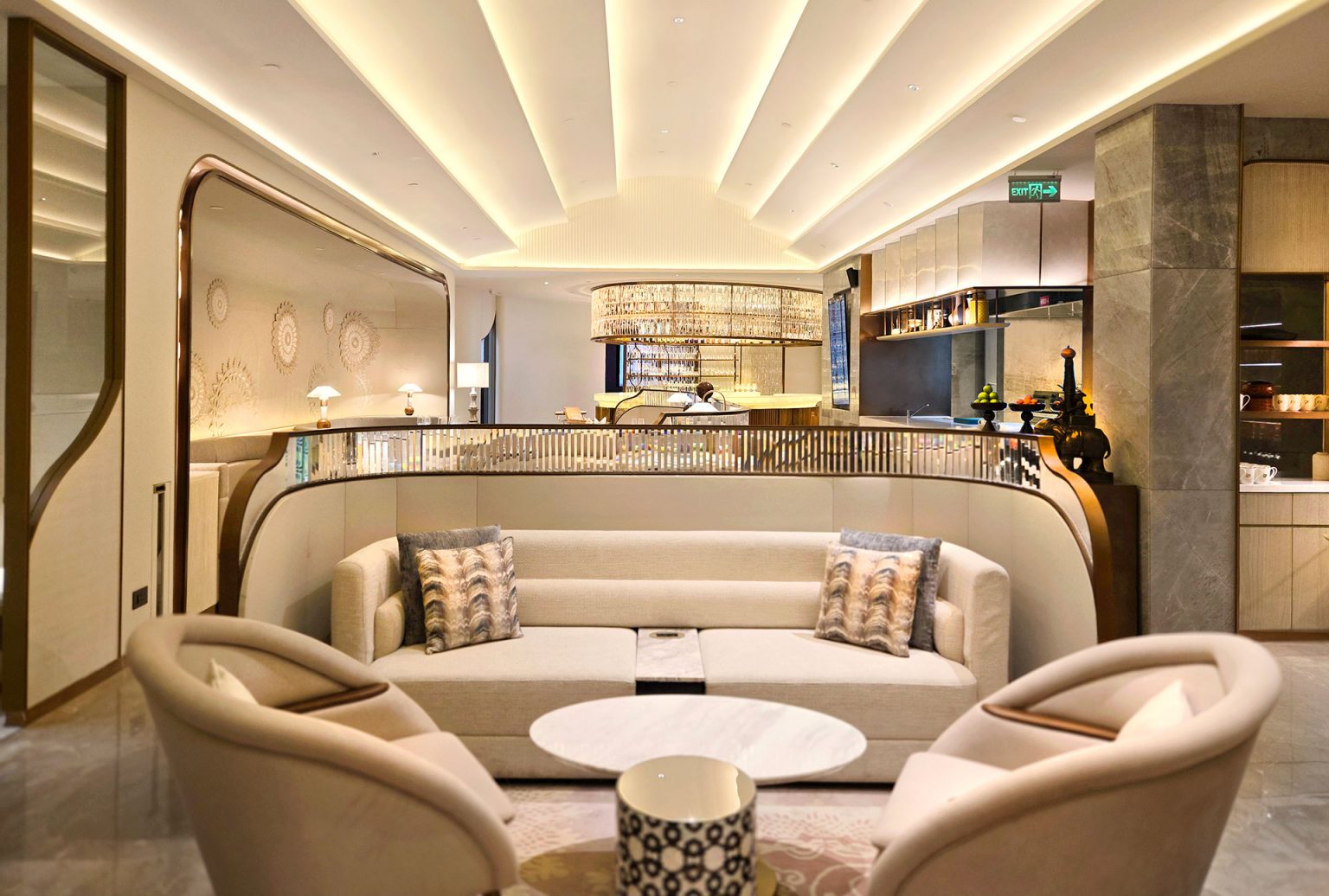 A stylish restaurant interior with two semi-circular booths featuring white plush chairs and set tables. Warm lighting and decorative wall patterns create an elegant ambiance.
